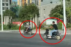 迷惑行为！桂林两男子翘二郎腿骑电动车！其中一人还双手离开车把图片