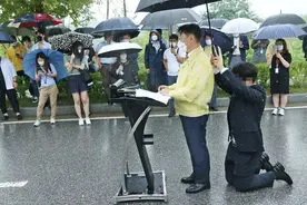 韩国官员台前宣扬保障人权，身后职员为其跪地撑伞…图片