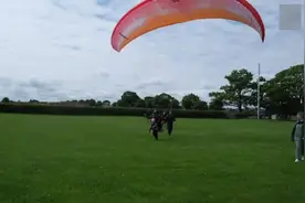 英国一名2岁小女孩和父亲一起乘滑翔伞在200米高空飞翔图片