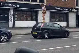 英国女子在车流中爬上车顶跳舞 被司机一拳打倒摔落地面图片