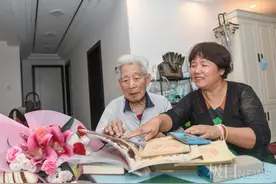 95岁老师迎50岁学生看望，收到鲜花，也收到自己35年前批过的作业本图片