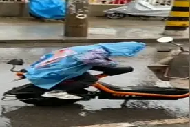 小暖男！妈妈下车买文具 九岁男孩用身子挡雨水防止电瓶车前座被淋湿图片