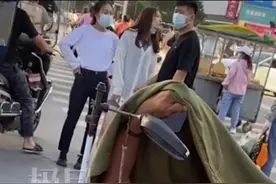 老夫妇郑州街头二维码乞讨，大妈坐着守摊，大爷被窝里玩手机图片