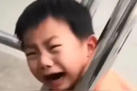 “爸爸，卡住了”，男娃头卡栏杆哭，父亲乐呵看戏，对话逗坏网友图片