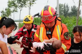 暖心！污泥浊水中消防员抱起三月大婴儿图片