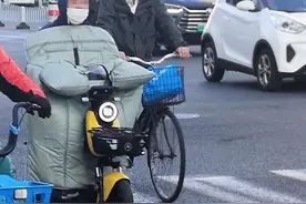 气温骤降 电动自行车“披挂上阵”保暖“挡风被” 骑行埋隐患图片