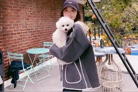 林允儿戴鸭舌帽穿着休闲，怀抱爱犬笑容灿烂甜笑满分图片