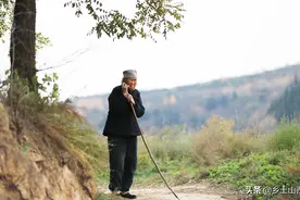 山村90岁独居老奶奶，拄着棍子寒风中村口等待，天冷了烧柴禾取暖图片