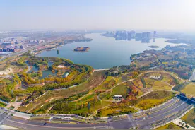 航拍郑州北龙湖湿地公园：秋意尚未走远，树木染黄润红，初冬景色美如画卷图片