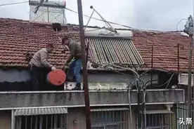 真悬！岳阳一居民楼顶上太阳能热水器，在风中摇摇欲坠图片