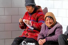 小山村天寒地冻，一群老人在屋檐下晒太阳，戴着眼镜纳鞋底也罕见图片
