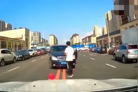 大连GL8女司机下车忘拉手刹致溜车，男子以臂挡车被挤在两车中间图片