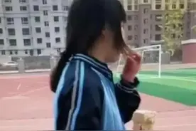 偌大的操场，只见女儿在操场的一棵树旁边，独自孤零零啃着馒头。图片