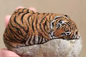 她在石头上画画，看起来很普通的石头，在她手中变成了艺术品图片