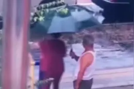 暖心！爷爷撑伞陪奶奶雨中锻炼图片
