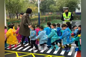 幼儿园老师带小朋友过马路，社会秩序教育意义重大，要从娃娃抓起图片
