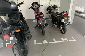 摩托车主在公共区域，用胶带自制停车位图片