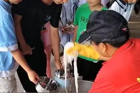 学校食堂员工用手抓米粉给学生打饭，遭网友质疑，校方：属个人行为，已解聘图片