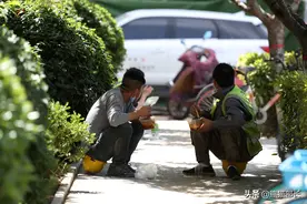 疫情下的民工生活不易 坐路边吃饭歇息图片