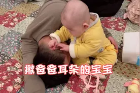 宝爸躺宝宝身边，六个月宝宝揪着爸爸耳朵不放，耳朵让宝宝揪通红视频封面