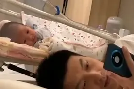 1个月宝宝被“哄睡”后偷看爸爸刷手机发笑，视频内容引网友好奇视频封面