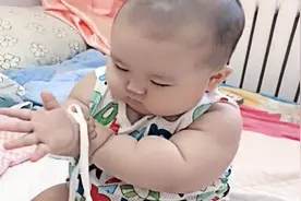 小萌宝把被套绳子玩出新花样，小手笨拙的动作，简直萌翻了！视频封面