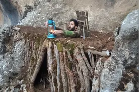 荒野的一处悬崖石壁上，用枯树枝搭建避难所，躲在里面安稳睡大觉视频封面