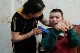单亲妈妈20年如一日照顾脑瘫儿子图片