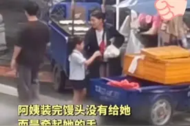 女孩独自过马路买馒头，摊主牵女孩护送过马路，人民日报转载点评图片