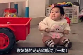 舅舅正在教育哥哥，外甥女扶着小车走到舅舅身边夺走竹条，顺利“解救”被训的哥哥图片
