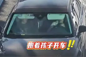 惊心！一女子抱娃开车还看手机！图片
