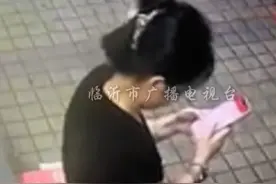女子站在路边玩手机，一只“小强”突然飞上身…
