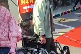 车模在台上表演，坐在轮椅上的大爷离太远看不清，一着急站了起来图片