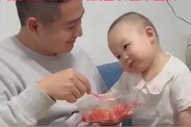 爸爸喂女儿吃西瓜，宝宝吃完一口后就开心的扭动。“果然女生吃到好吃的东西都会扭来扭去。”图片