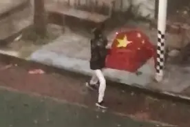 男孩在暴风雨中奋力保护国旗，校长回应：这是他的自发行为，平时升旗他也最积极，非常肯定他的勇敢图片