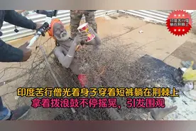 印度苦行僧光着身子整天躺在荆棘上，拿着拨浪鼓摇摆，引发围观图片