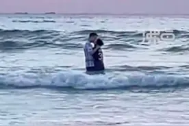 情侣站在海浪里拥吻险些被冲倒，目击者：数百人等待看日出，日出没看到，全看他们了图片