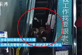 杭州火车站一旅客乘扶梯摔倒，民警十秒冲上前扶起图片