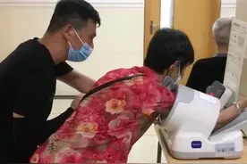 男子用腿当板凳扶母亲测血压，姐姐：医院座位满了，该换我们照顾父母了图片