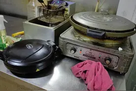 芝罘区东方巴黎小区内食品摊位中午做饭影响休息 摊主：将拆除店内油炸锅图片