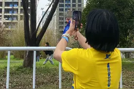 武汉马拉松首次在樱花季开跑，半马选手冲线后举牌和樱花合照：粉粉的，很配图片