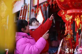 组图|两岁萌娃逛年集，蹦蹦跳跳满脸笑图片