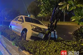 男子深夜开车犯困，小轿车冲上隔离带图片