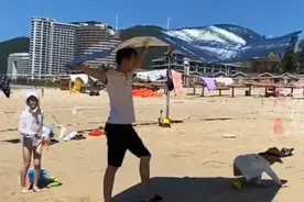女儿在沙滩玩耍，爸爸化身移动遮阳伞，网友：连风都在给爸爸帮忙图片