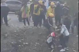 三轮车翻入数米深河沟，十多名外卖员借钢丝绳合力拉出图片