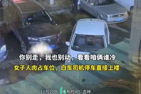 女子人肉占车位，白车司机直接停车上楼。“你别走，我也别动，看看咱俩谁冷。”图片