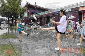 一场阵雨给西安降温 雨后大雁塔北广场上市民戏水图片