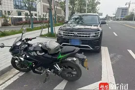 粗心司机停车忘拉手刹，前溜撞坏路边摩托车图片
