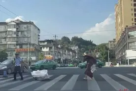 雅安街头暖心一幕：拾荒老奶奶艰难过街 00后辅警上前帮拖小车，带她过马路图片