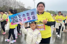 樱花季 越江湖｜女儿举牌为妈妈加油，之后还要去全马终点接爸爸图片